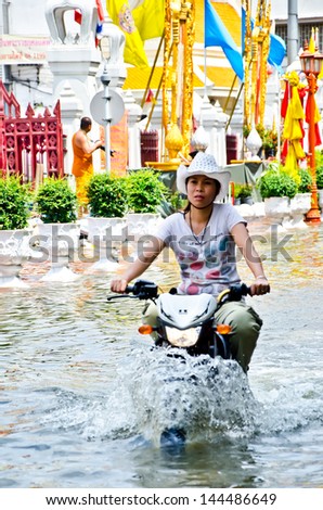 BANGKOK, THAILAND - OCT 30: An unidentified motorbike rider navigates a flooded street after the heaviest monsoon rains in over 50 years on October 30, 2011 in Bangkok, Thailand
