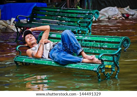 BANGKOK, THAILAND - OCT 31: Flood victim becomes homeless, sleep on bench at Bangkok\'s Chinatown on October 31, 2011 in Bangkok, Thailand