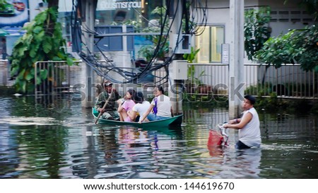 BANGKOK, THAILAND - NOV 5: Unidentified people travel by boat and bike  in the street on Jaransanitwong Road during the worst flooding  on November 5, 2011 in Bangkok, Thailand
