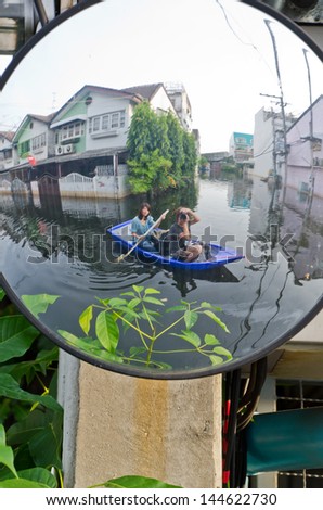 BANGKOK, THAILAND - NOV 5: Scene from defensive driving mirror with  flooded house  reflected on it during the worst flooding on November 5, 2011 in Bangkok, Thailand