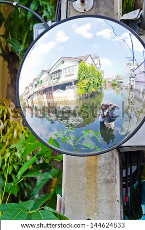 BANGKOK, THAILAND - NOV 11: Scene from defensive driving mirror with  flooded house  reflected on it during the worst flooding on November 11, 2011 in Bangkok, Thailand