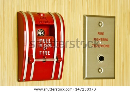 Red Fire alarm and fire fighter telephone on the wooden wall