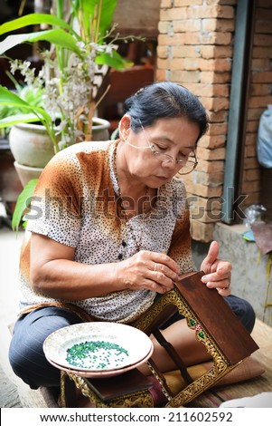 CHIANGMAI, THAILAND - JULY 28: An unidentified woman builds altar table at Bann Tawai on July 28, 2014  in Chiang Mai,Thailand. Baan Tawai is the village of wood-carving handicrafts in Thailand.