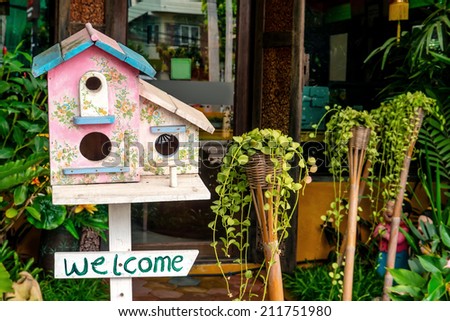 Colorful wooden bird house with welcome sign