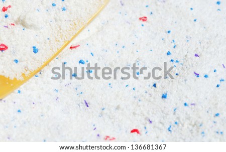 Washing powder and measuring cup on powder background
