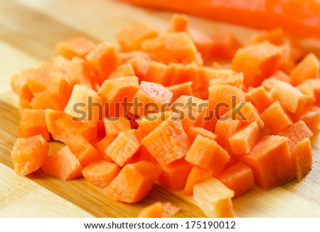 Diced carrots  on wooden chopping board.