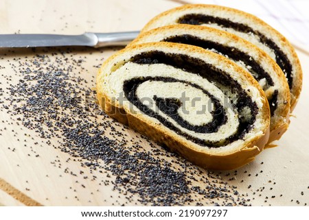 Poppy seed Roll on a wooden surface, closeup.