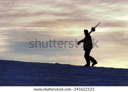 Silhouette of a skier climbing .