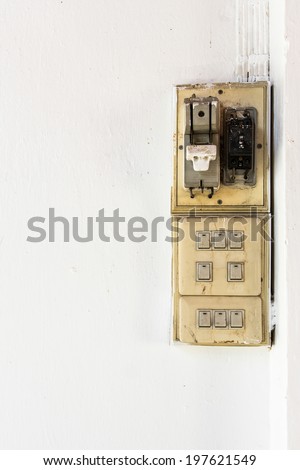 Old electricity switch breaker on white wall