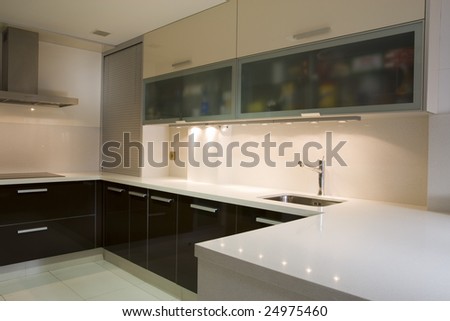Modern kitchen with cream and chocolate cupboards and steel hood