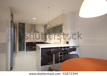 Modern kitchen with cream and chocolate cupboards and inox hood