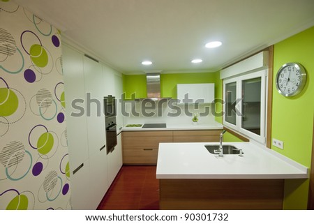 Modern kitchen with white and wood cupboards and steel hood