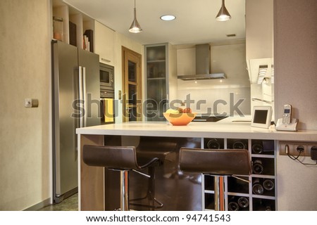 Modern kitchen with cream and chocolate cupboards and steel hood
