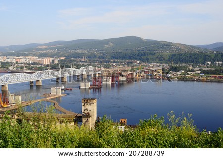 City of Krasnoyarsk view. The Fourth Road Bridge building site on the river Yenisei. Industrial cityscape. Siberia, Russia. Summer day, July 22, 2014.