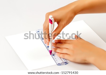 girl draws a pen on a ruler on paper