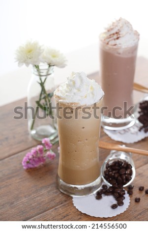 two Ice coffee with flower and coffee beans on a wood table