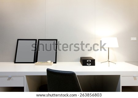Workspace with desk lamp and picture frame on home or studio