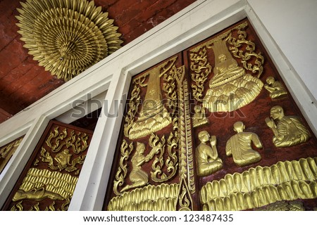 Wooden doors of Thai temple which crafted with images of Buddha\'s story. This kind of art can be commonly seen in Buddhist temples.