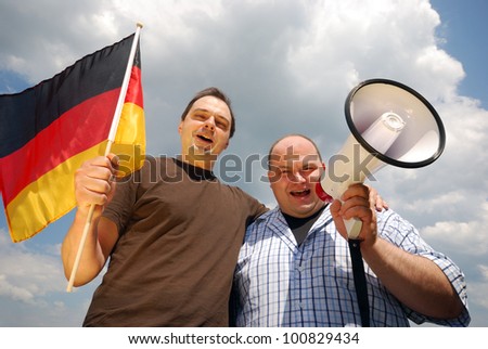two happy men with megaphone and german flag