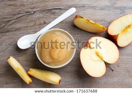small bowl of apple puree with a fresh apple