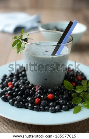 glass of blueberry soy drink with fresh fruits