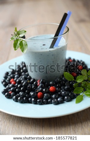 glass of blueberry soy drink with fresh fruits