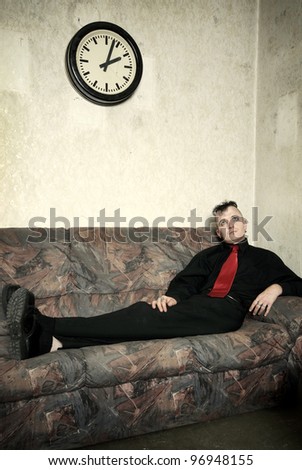 portrait of a strange businessman on an old couch