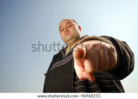 man pointing at you in front of blue sky