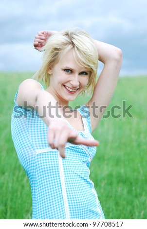 smiling young woman pointing at you