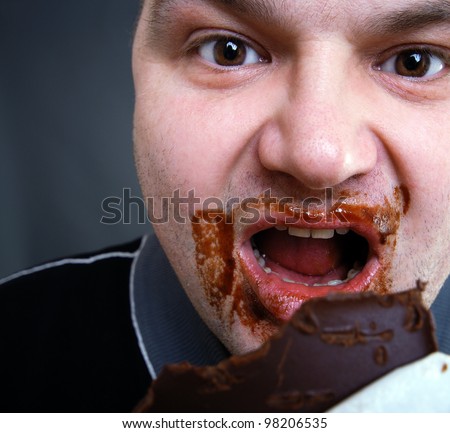 greedy man eats a chocolate bar