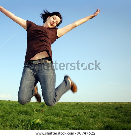 happy woman jumps on a meadow