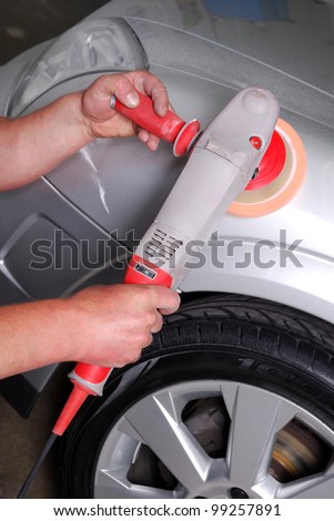 car mechanic polishes the auto paint