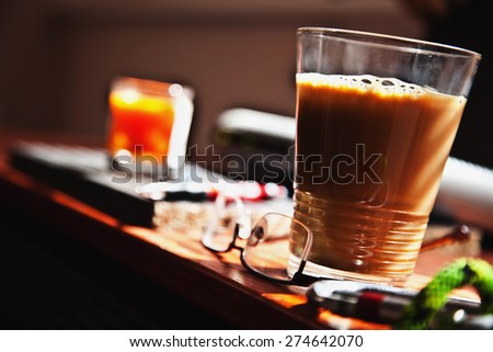 Coffee in glass cup on cluttered desk