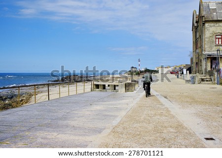 Esposende, PORTUGAL - April 22: Senior drives a bike on promenade along the Apulia beach on April 22 in Esposende, Portugal. Apulia beach is part of Parque Natural do Litoral on the north of Portugal.