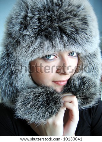 Beautiful girl in fur cap and blue eyes