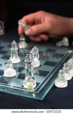 Set of glass chess, hand holding figure