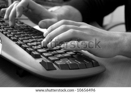Male hands typing on keyboard, black and white image