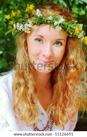 portrait of beautiful sunny redhead girl in flower diadem