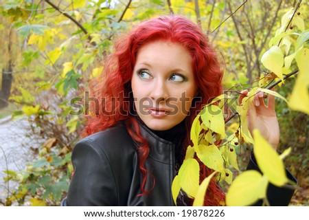 red haired gothic type girl near autumn tree