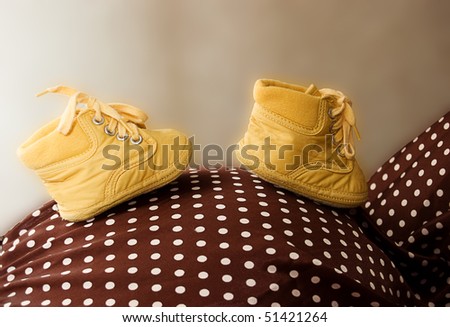 Baby shoes on pregnant mother\'s belly