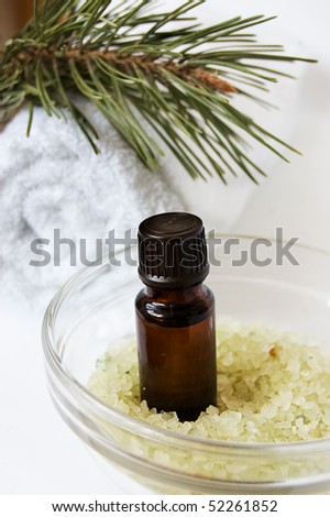 Bottle of fir tree oil and salt over white