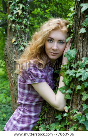Redheaded woman near tree with climber plant
