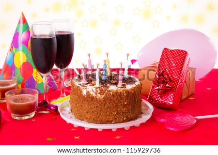 Birthday table with cake, candles, wine and gifts