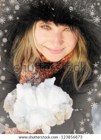 Blond woman in winter hat and gloves with snowflakes
