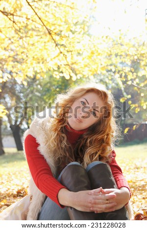 Smiling woman under autumn golden trees