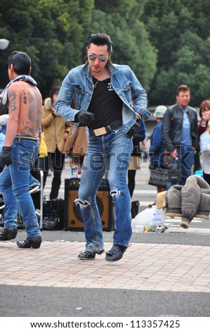 TOKYO - APRIL 1 : Japanese men in rock and roll style outfit  perform group dancing near the entrance of Yoyogi Park in Tokyo on April 1 2012. They usually perform at Yoyogi Park on weekends.