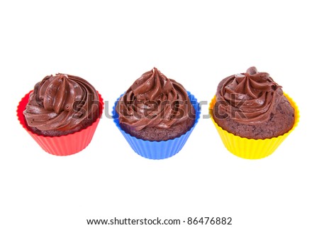 Three chocolate cupcakes in red, blue and yellow holders