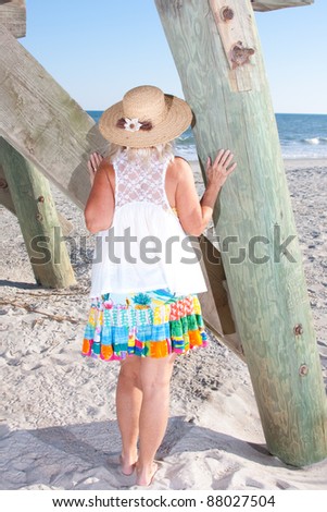Woman looking out  at the ocean from under the pier