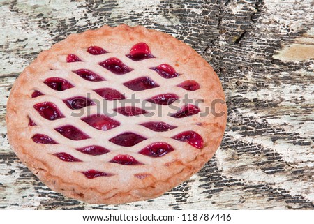 Fresh homemade cherry pie on a piece of distressed wood