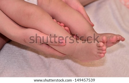 Mommy hold baby\'s little foot